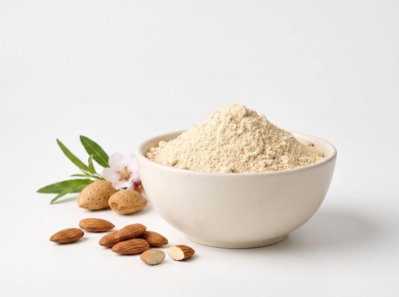 Helles Proteinpulver in weißer Schale mit Mandeln und Mandelblüten
